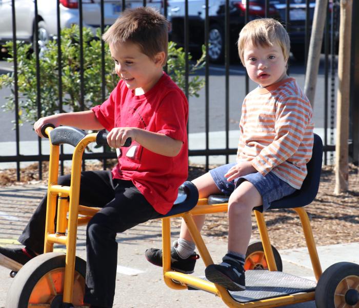 Two preschool children riding together on a bike