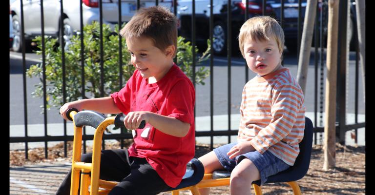 Two preschool children riding together on a bike